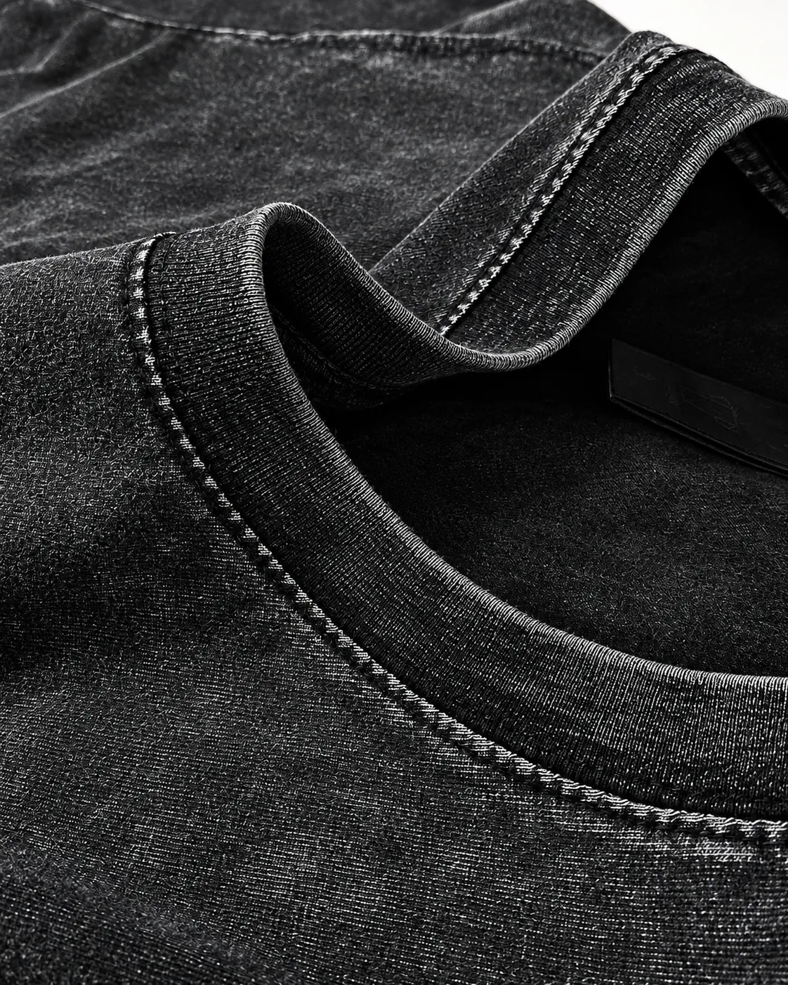 Detalhe da gola em anel de uma camiseta preta